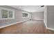 A naturally lit living room featuring gray walls, white trim, laminate flooring, and large windows at 1528 Alder Sw Ln, Atlanta, GA 30311
