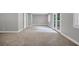 Large living room with carpet flooring, neutral paint, and outdoor access through french doors at 1528 Alder Sw Ln, Atlanta, GA 30311