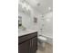 Well-lit bathroom with a single sink vanity, framed mirror, and tub-shower combo at 1628 Baytree Dr, Cumming, GA 30040