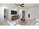 Bright living room with ceiling fan, flat-screen TV, and views to laundry room in modern home at 1628 Baytree Dr, Cumming, GA 30040