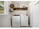 Functional laundry room with shelving, side window for natural lighting and modern appliances at 205 Tamea Trl, Covington, GA 30014