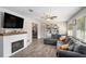 Cozy living room with a modern fireplace, large sectional sofa, and bright windows, perfect for relaxation at 205 Tamea Trl, Covington, GA 30014
