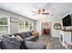 Bright living room with a large sectional sofa, modern fireplace, and multiple windows, creating an inviting space at 205 Tamea Trl, Covington, GA 30014