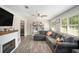 Cozy living room with a modern fireplace, large sectional sofa, and bright windows, perfect for relaxation at 205 Tamea Trl, Covington, GA 30014