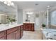 Bright primary bath featuring dual vanities, a soaking tub, and a glass-enclosed shower at 4905 Greylock Se Walk, Atlanta, GA 30339