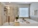 Clean bathroom featuring a glass-enclosed shower and a soaking tub at 4905 Greylock Se Walk, Atlanta, GA 30339