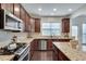 Gourmet kitchen with stainless steel appliances, granite counters, and dark wood cabinets at 4905 Greylock Se Walk, Atlanta, GA 30339