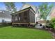 Large backyard featuring a screened porch, seating area with fire pit, lush lawn, and mature landscaping at 1671 Laurel Nw Ave, Atlanta, GA 30318