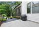 Landscaped patio area with grill, seating, a stone fire pit and view of the screened in porch above at 1671 Laurel Nw Ave, Atlanta, GA 30318