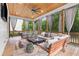 Inviting screened porch with wood ceiling, ceiling fan, fireplace, outdoor seating, and dining area at 1671 Laurel Nw Ave, Atlanta, GA 30318