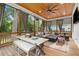 Relaxing screened porch with wood ceiling, ceiling fan, outdoor furniture, fireplace, dining table, and curtains at 1671 Laurel Nw Ave, Atlanta, GA 30318