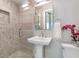 Modern bathroom with a tiled shower, pedestal sink, and sleek fixtures at 175 Stovall Se St, Atlanta, GA 30316