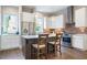 Modern kitchen featuring stainless steel appliances, white cabinetry, brick backsplash, and an island with seating at 175 Stovall Se St, Atlanta, GA 30316