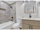 This bathroom has a tub with marble style tiled walls and updated sink and vanity at 2017 Allwood Ct, Lawrenceville, GA 30044