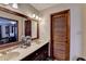 Spacious bathroom featuring double vanity, framed mirror, and door to main bedroom at 2130 Monticello Pl, Lawrenceville, GA 30043