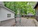 Back deck features a round table and is surrounded by mature trees at 2130 Monticello Pl, Lawrenceville, GA 30043