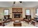 Cozy living room with brick fireplace, leather chairs, and neutral rug creating an inviting space at 2130 Monticello Pl, Lawrenceville, GA 30043