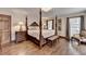 Comfortable main bedroom with a four-poster bed, hardwood floors, and stylish decor at 2130 Monticello Pl, Lawrenceville, GA 30043