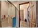 Clean glass-enclosed shower with built-in shelf in a bathroom with a view to a wooden door at 2130 Monticello Pl, Lawrenceville, GA 30043