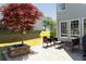 Backyard featuring a brick patio with a fire pit and outdoor seating near home and colorful tree at 630 Bluff Oak Ct, Roswell, GA 30076