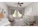 Cozy Bedroom featuring soft colors, a crib, glider, and dinosaur-themed rug at 630 Bluff Oak Ct, Roswell, GA 30076