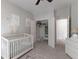 Bedroom with a white crib, soft rug, and organized closet storage at 630 Bluff Oak Ct, Roswell, GA 30076