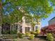 Inviting brick home featuring a meticulously landscaped front yard with lush greenery and mature trees at 630 Bluff Oak Ct, Roswell, GA 30076