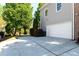 House exterior showcasing a two-car garage, mature trees, and a well-maintained driveway at 630 Bluff Oak Ct, Roswell, GA 30076