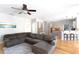 Open-concept living room with a large sectional sofa, hardwood floors, and access to the kitchen at 630 Bluff Oak Ct, Roswell, GA 30076