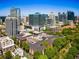 Aerial view of apartments with a rooftop pool surrounded by greenery and a dynamic cityscape at 850 Piedmont Ne Ave # 2509, Atlanta, GA 30308