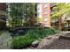 A tranquil courtyard features garden seating, greenery, and mature trees around the brick building at 850 Piedmont Ne Ave # 2509, Atlanta, GA 30308