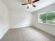 Cozy bedroom with carpet flooring, a ceiling fan, and a bright window view at 1098 Eastview Ne Cir, Conyers, GA 30012