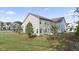 View of the house's back exterior featuring a pristine lawn and young tree at 305 Knights Ct, Canton, GA 30115