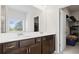 Bathroom featuring double vanity sinks, dark cabinets, a large mirror, and a walk-in closet at 305 Knights Ct, Canton, GA 30115