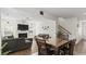 Open-concept living area with a dining table, fireplace, and access to the staircase at 305 Knights Ct, Canton, GA 30115
