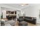 Open-concept living room features hardwood floors, a large sectional sofa, and a view into the dining and kitchen area at 305 Knights Ct, Canton, GA 30115