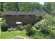 Aerial view of brick home featuring a lush backyard, patio, and wooded surroundings at 4360 Pleasant Forest Dr, Decatur, GA 30034