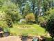 Lush backyard featuring a storage shed nestled amongst trees, shrubs, and landscaped garden beds at 4360 Pleasant Forest Dr, Decatur, GA 30034