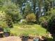 Lush backyard featuring a storage shed nestled amongst trees, shrubs, and landscaped garden beds at 4360 Pleasant Forest Dr, Decatur, GA 30034