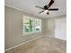 Bedroom with beige walls and carpet and lighted ceiling fan has one window and a closet at 4360 Pleasant Forest Dr, Decatur, GA 30034