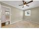 Bedroom with beige walls and carpet with lighted ceiling fan and one window, view through open door into another bedroom at 4360 Pleasant Forest Dr, Decatur, GA 30034