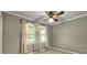 Bedroom with gray walls and neutral carpet and lighted ceiling fan has natural light from two curtained windows at 4360 Pleasant Forest Dr, Decatur, GA 30034