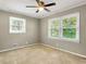 Bedroom with beige walls and carpet and lighted ceiling fan has natural light from two windows at 4360 Pleasant Forest Dr, Decatur, GA 30034