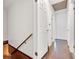 Hallway with white walls and hardwood floors with a closed door to the left and view to a light fixture on the ceiling at 4360 Pleasant Forest Dr, Decatur, GA 30034