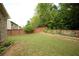 Large, well-maintained backyard featuring a wooden fence, lush lawn, and charming landscaping at 1142 Terrasol Rdg, Lilburn, GA 30047