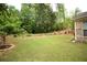 Expansive backyard with mature trees, a tiered stone garden, and well-kept lawn, ideal for outdoor enjoyment at 1142 Terrasol Rdg, Lilburn, GA 30047
