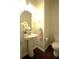 Elegant powder room featuring a pedestal sink, oval mirror, and modern fixtures with dark wood floors at 1142 Terrasol Rdg, Lilburn, GA 30047