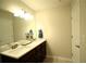Bathroom featuring double sink vanity with ample lighting and neutral color palette at 1142 Terrasol Rdg, Lilburn, GA 30047