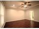 Spacious bedroom with dark wood-look floors, tray ceiling, fan, and access to an en suite bathroom at 1142 Terrasol Rdg, Lilburn, GA 30047