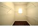 Walk-in closet with wood-look floors, shelving, and a window for natural light at 1142 Terrasol Rdg, Lilburn, GA 30047